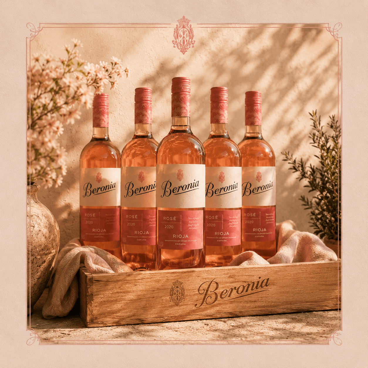 Cinq bouteilles de rosé Beronia Rioja dans une caisse en bois sous une lumière dorée.